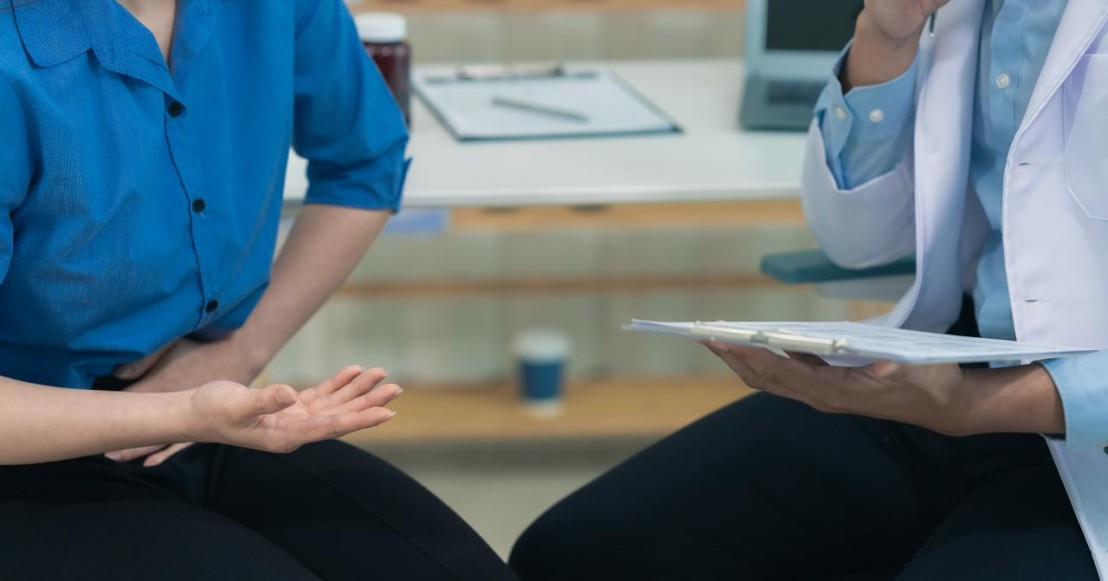 Une femme et un médecin assis discutent des symptômes, des causes et des traitements naturels des infections urinaires