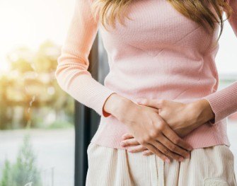 Jeune femme qui souffre de ses règles et qui se touche le ventre