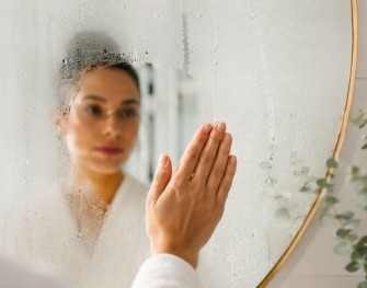 Femme en peignoir dans sa salle de bain