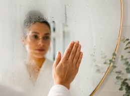 Femme en peignoir dans sa salle de bain
