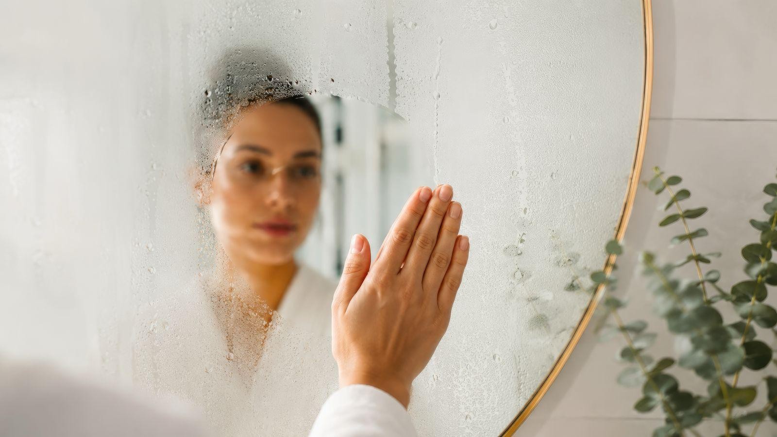 Femme en peignoir dans sa salle de bain